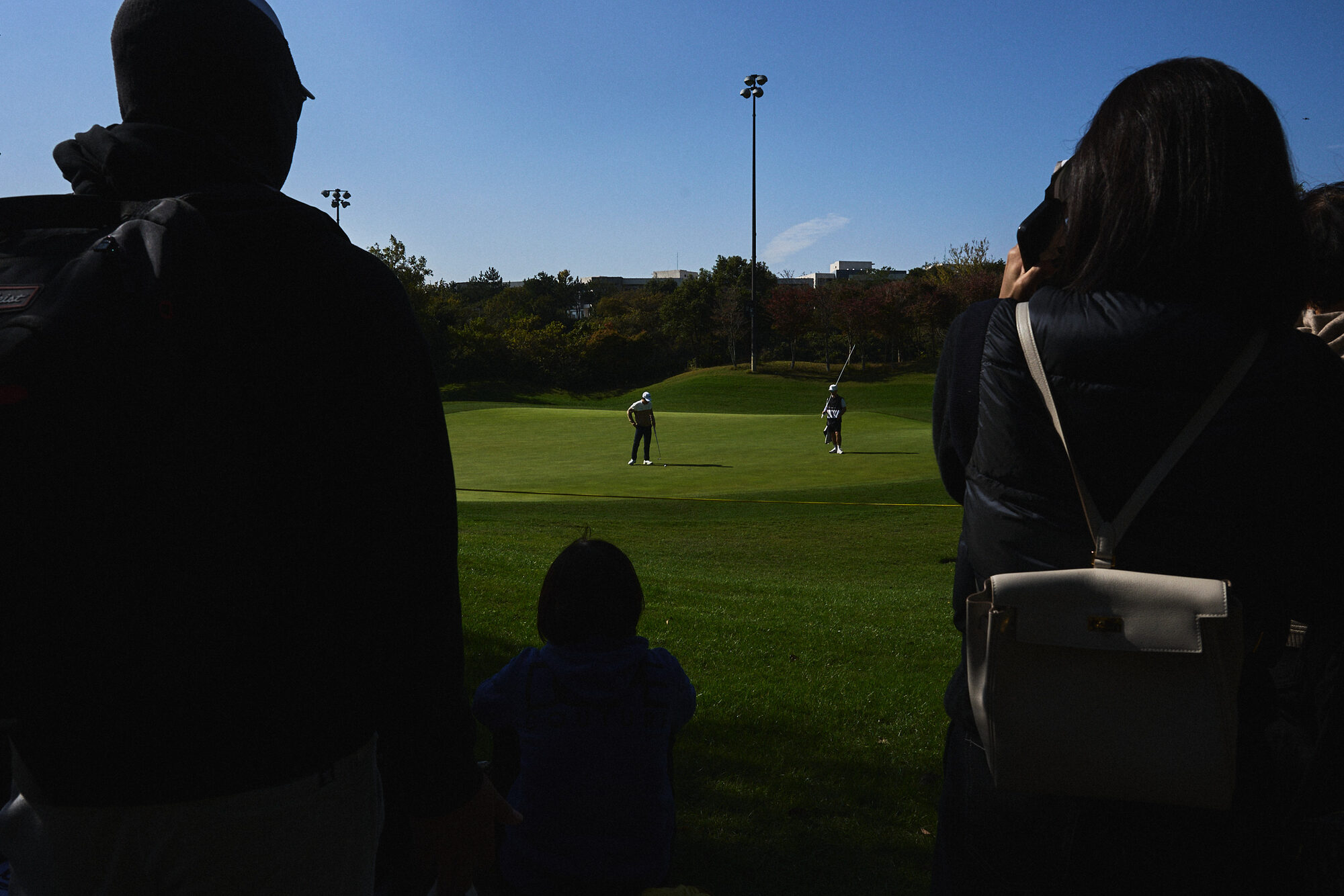 A moving figure and a player on the course during the KPGA event in Jeju. Image 3.