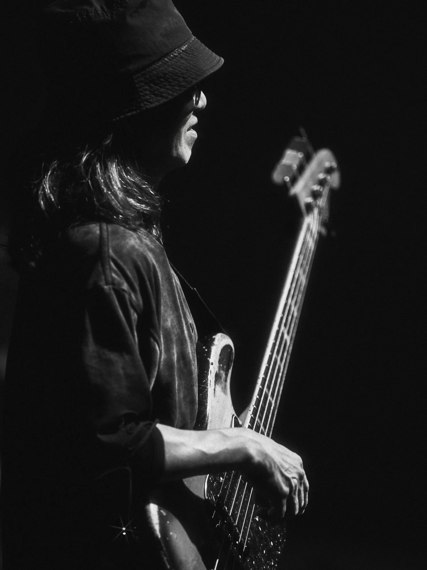 A black-and-white image of the performer singing under stage lights. Image 8.