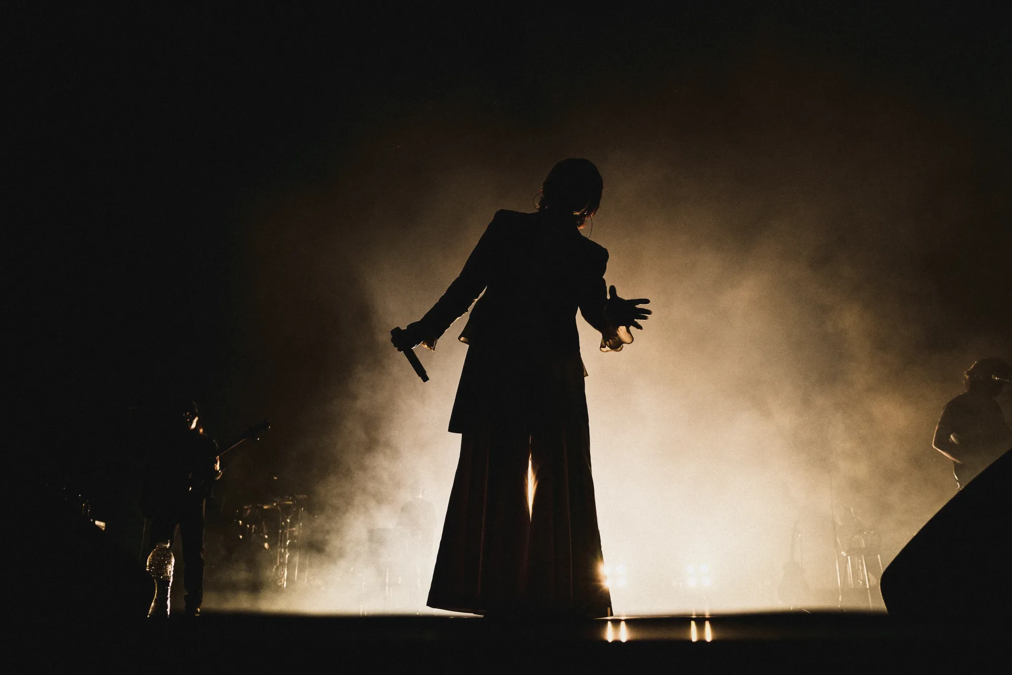 A black-and-white image of the performer singing under stage lights. Image 10.