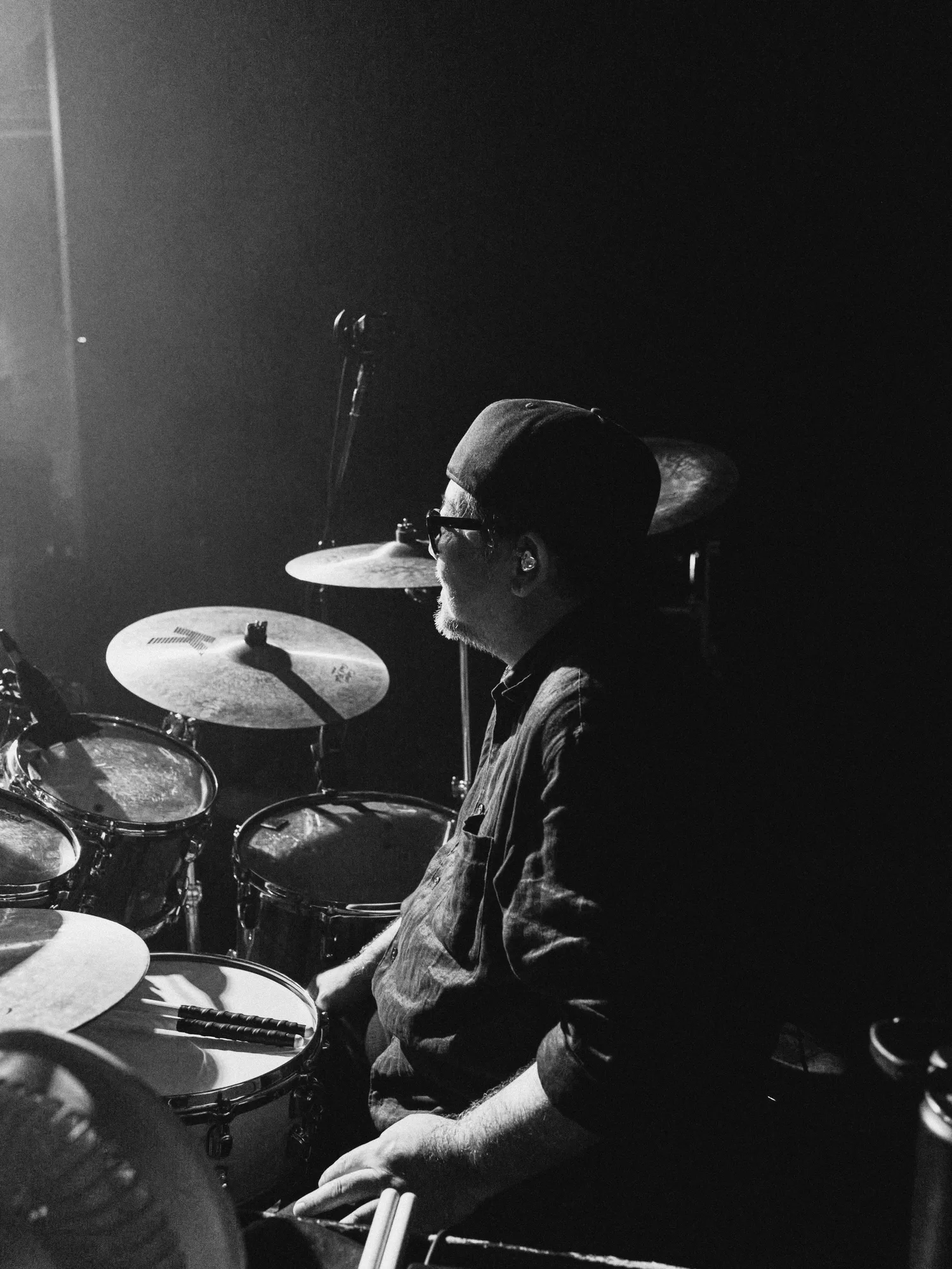 A black-and-white image of the performer singing under stage lights. Image 11.