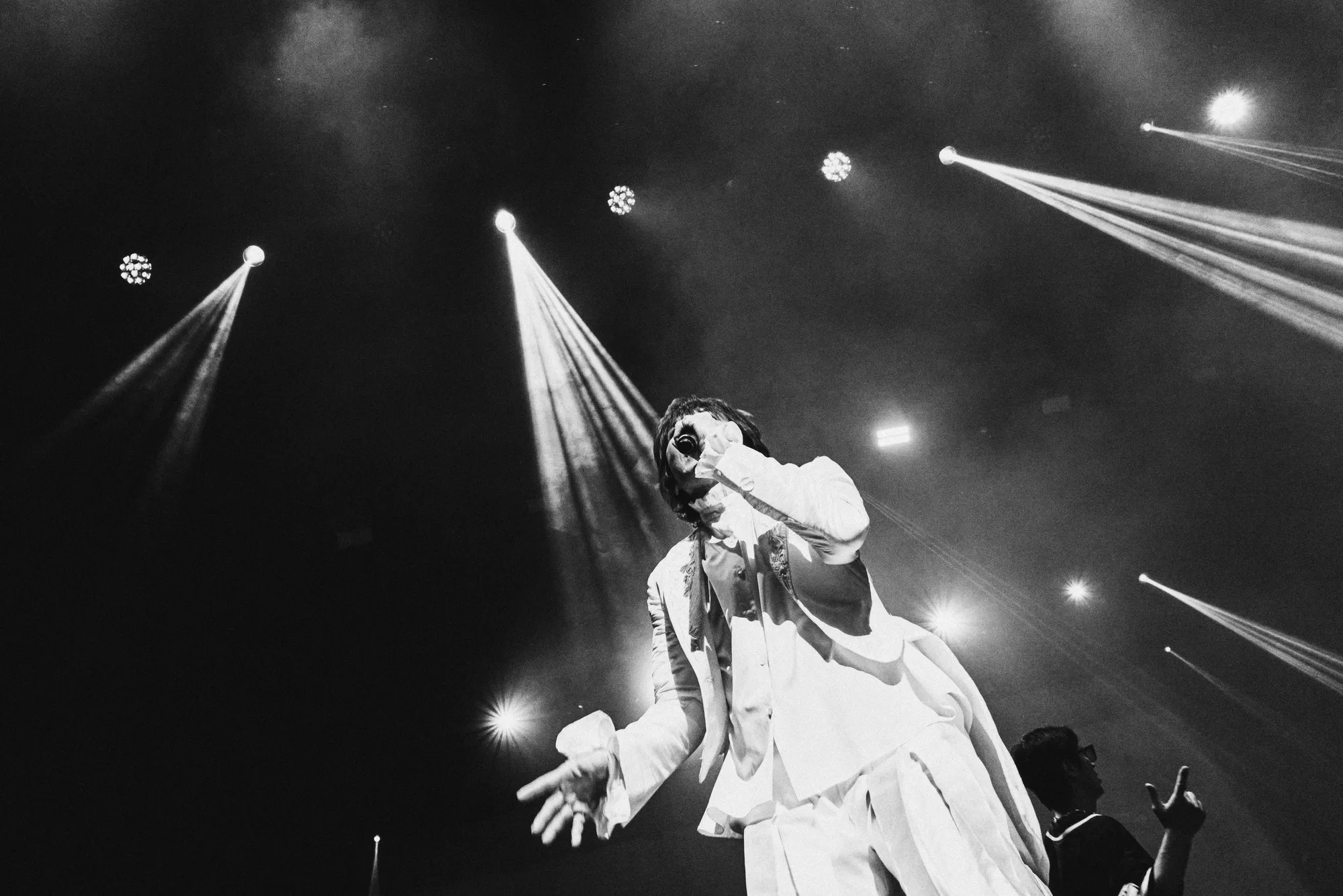 A black-and-white image of the performer singing under stage lights. Image 17.