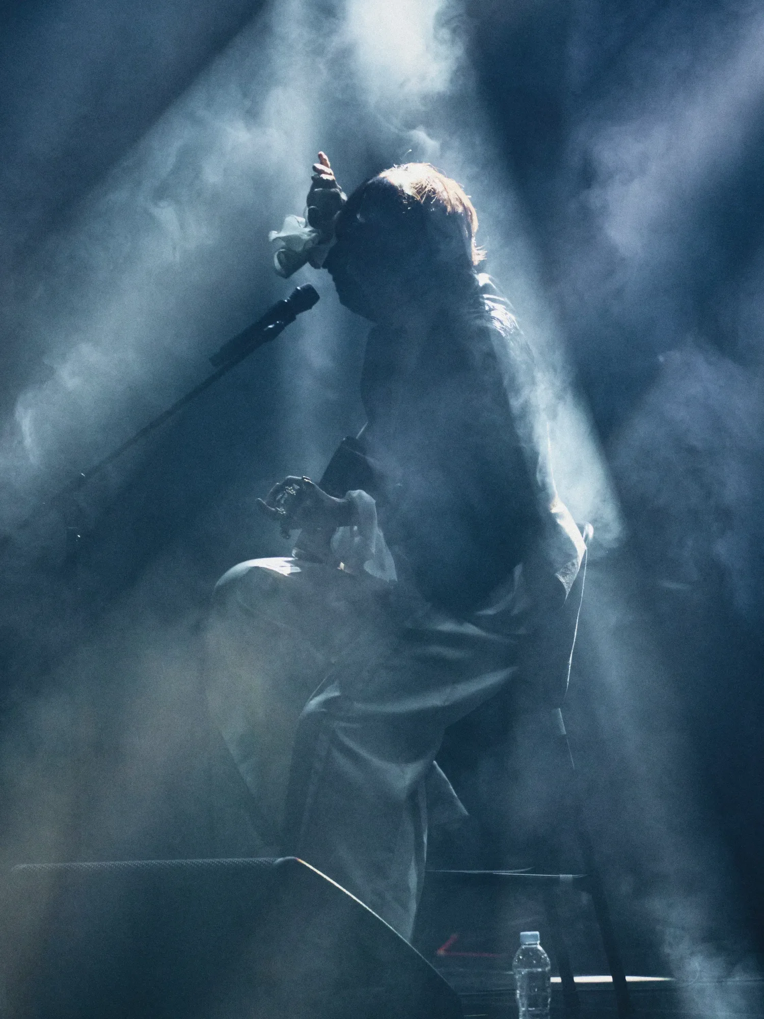 A black-and-white image of the performer singing under stage lights. Image 19.
