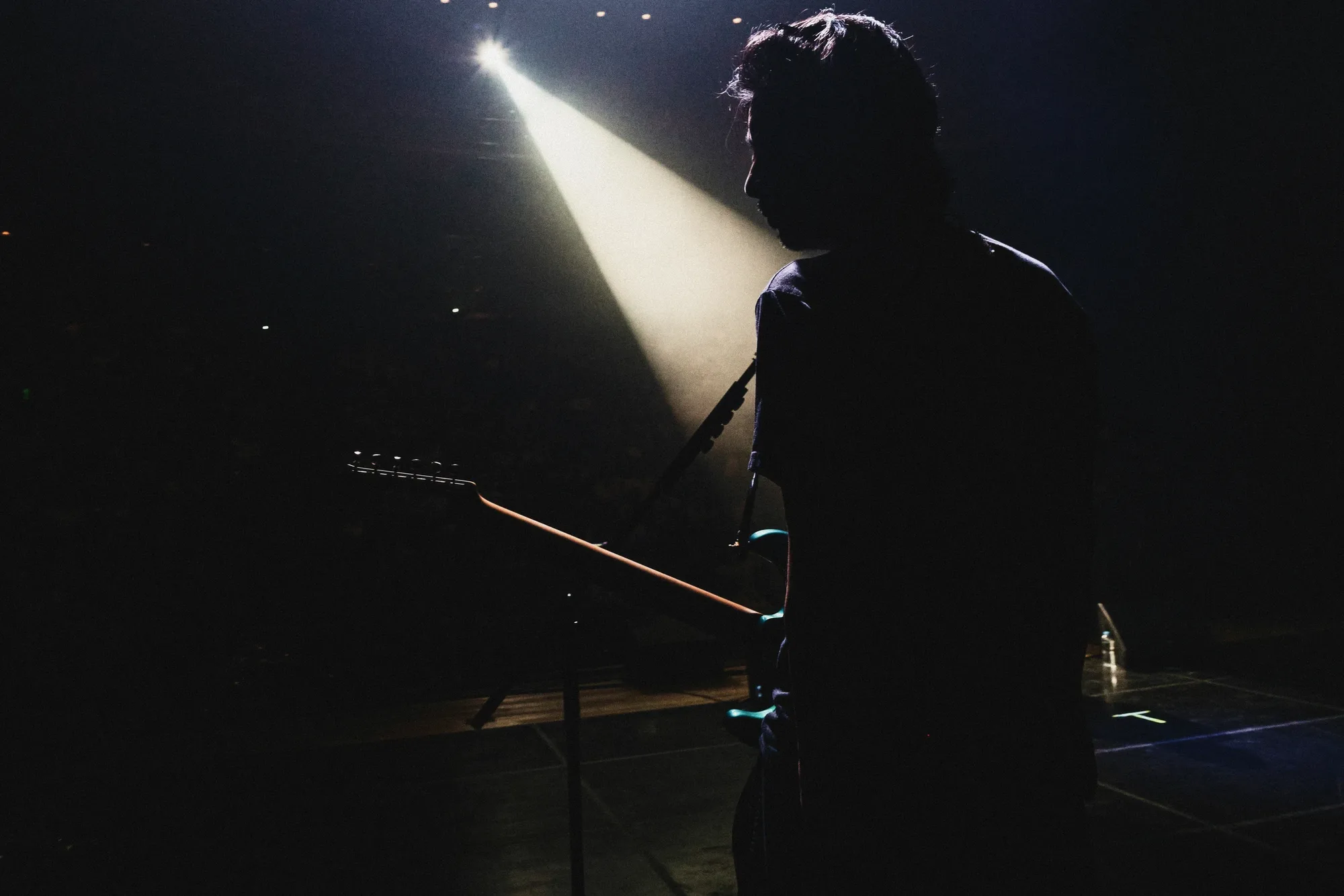 A black-and-white image of the performer singing under stage lights. Image 27.