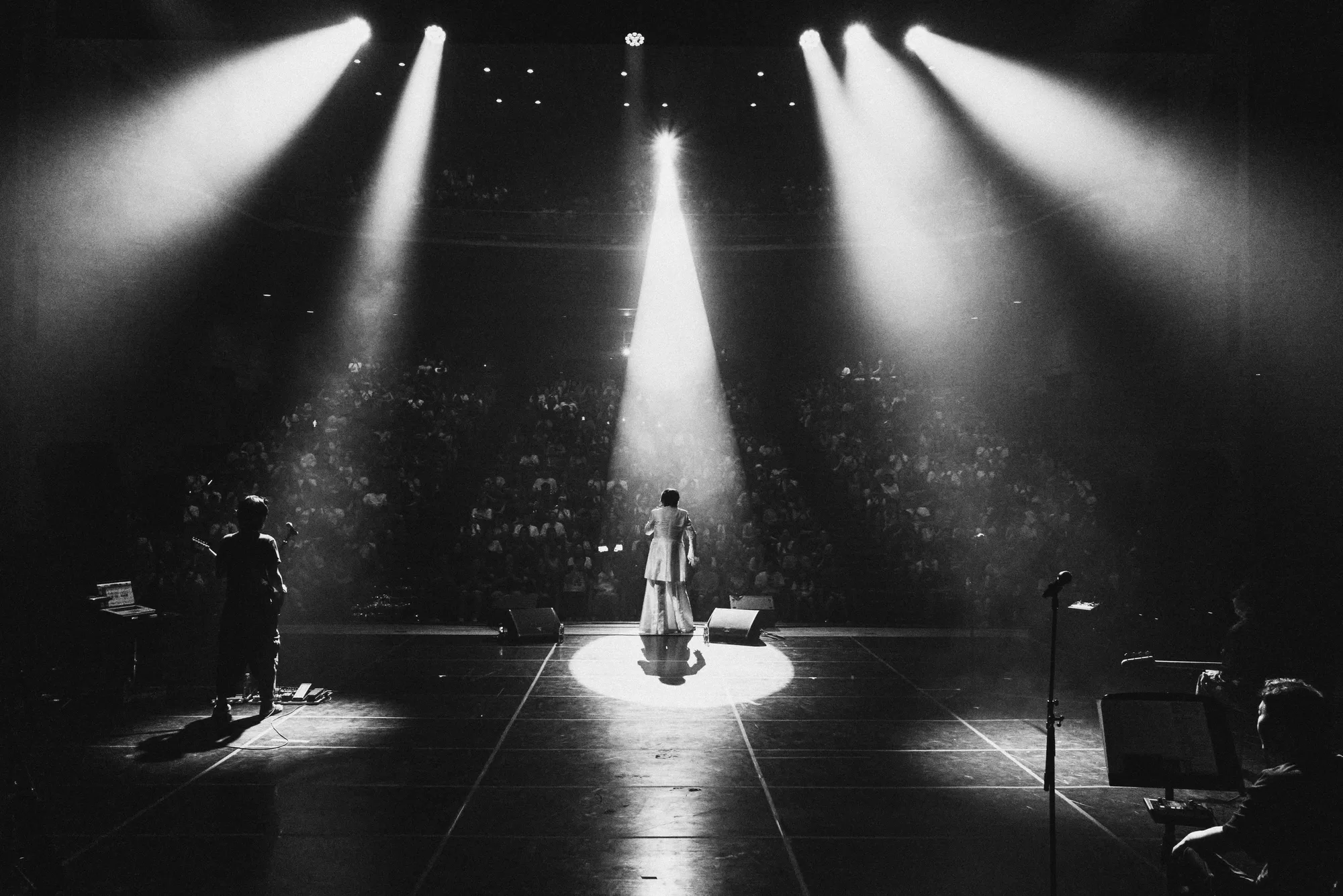A black-and-white image of the performer singing under stage lights. Image 30.
